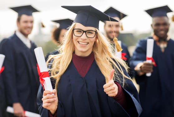 Absolventin im Talar hält Diplomrolle – Profil gezielt mit Master oder Doktorat schärfen